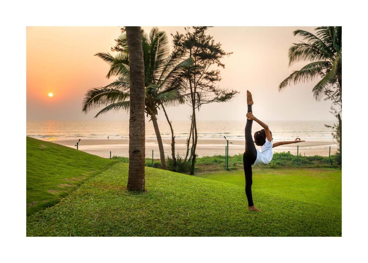 Caravela Beach Resort Varca Extérieur photo A woman practicing yoga at the beach